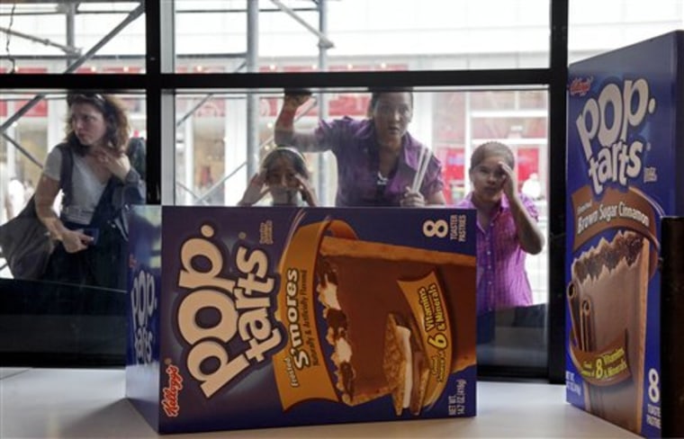 People peer in the window of the Pop-Tarts World store, Monday, Aug. 9, 2010, in New York's Times Square. One of Kellogg Co.'s most popular brands is popping up in Times Square on Tuesday at Pop-Tarts World, with more than 3,000 square-feet dedicated to the toaster pastries. (AP Photo/Richard Drew)